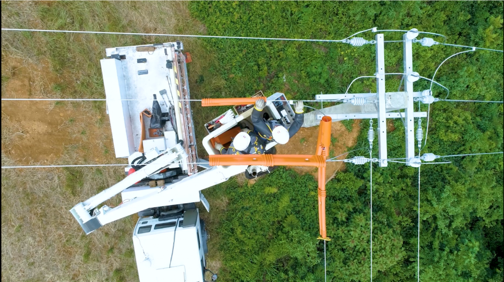 Imagem aérea de eletricistas trabalhando em rede da Copel