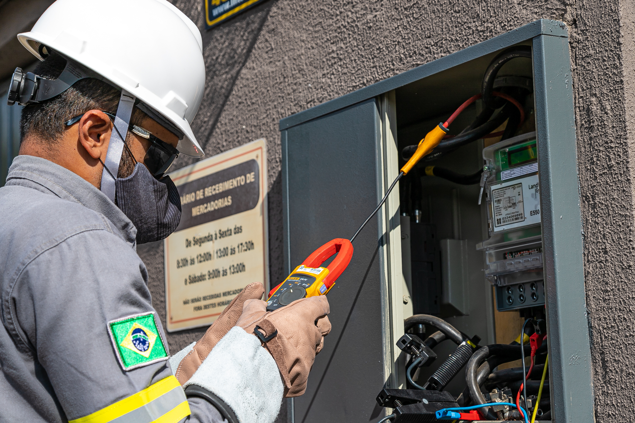 Eletricista inspeciona uma entrada de serviço