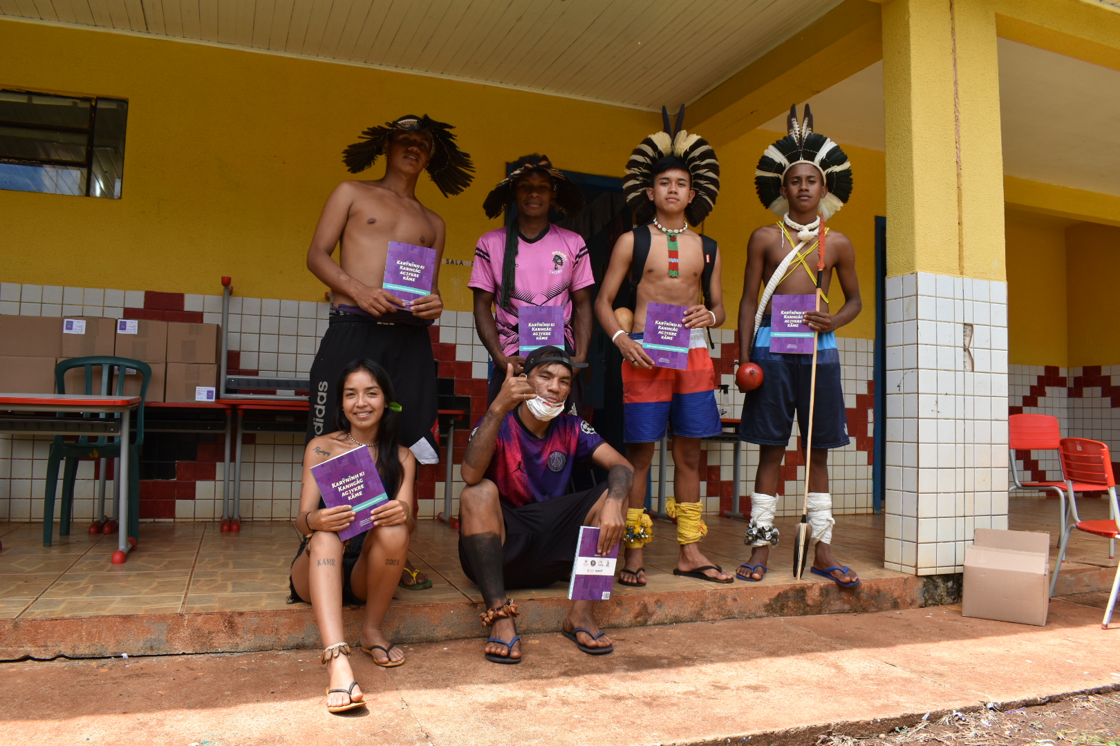 Jovens Kaingang mostram o livro que conta histórias da comunidade