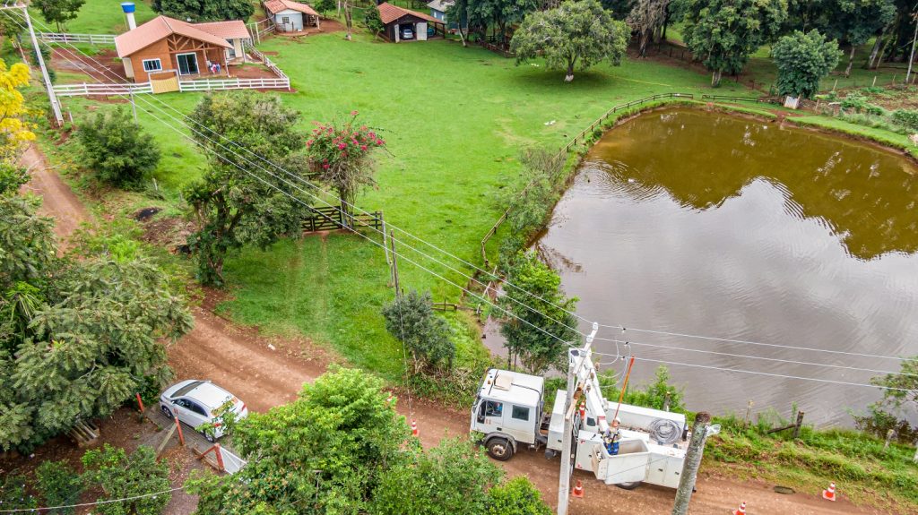 Obra do Paraná Trifásico rede elétrica ao lado de lago na área rural