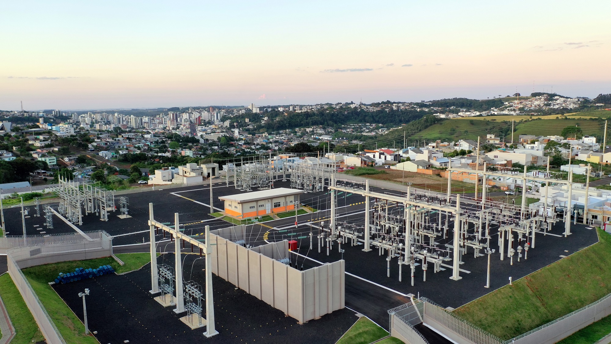 Vista aérea da subestação de energia ao pôr do sol com cidade de Pato Branco ao fundo