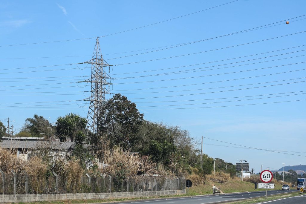 Torre de alta tensão em paisagem de estrada