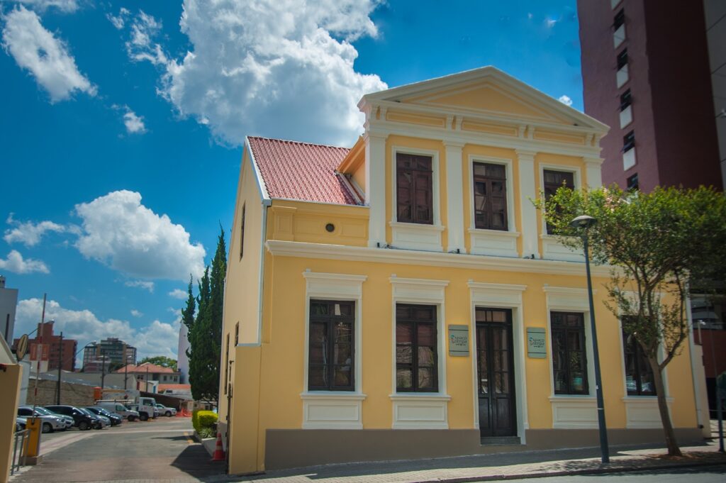 Fachada do casarão amarelo na rua Desembargador Mota em dia de céu azul