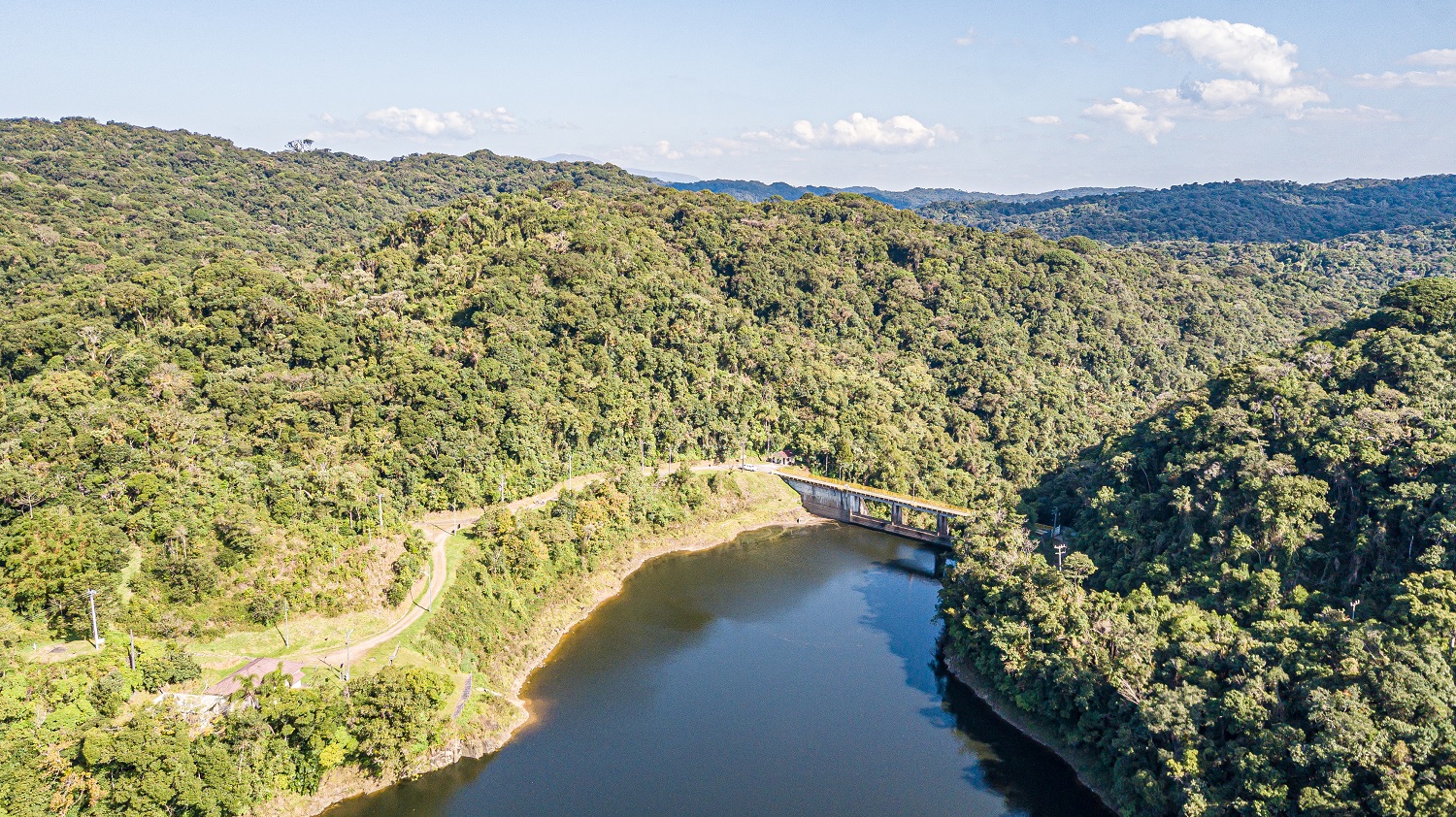 Vista aérea da PCH Guairicana, com vegetação de mata em torno do rio