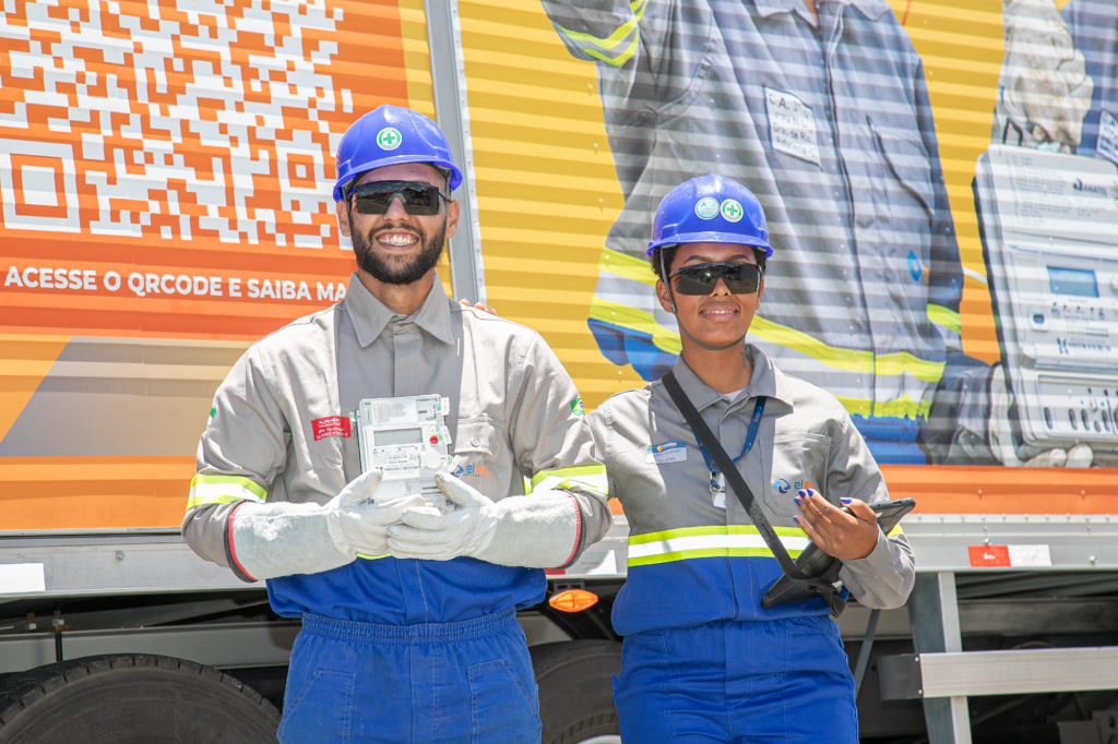 Dupla de eletricistas segurando um medidor de energia