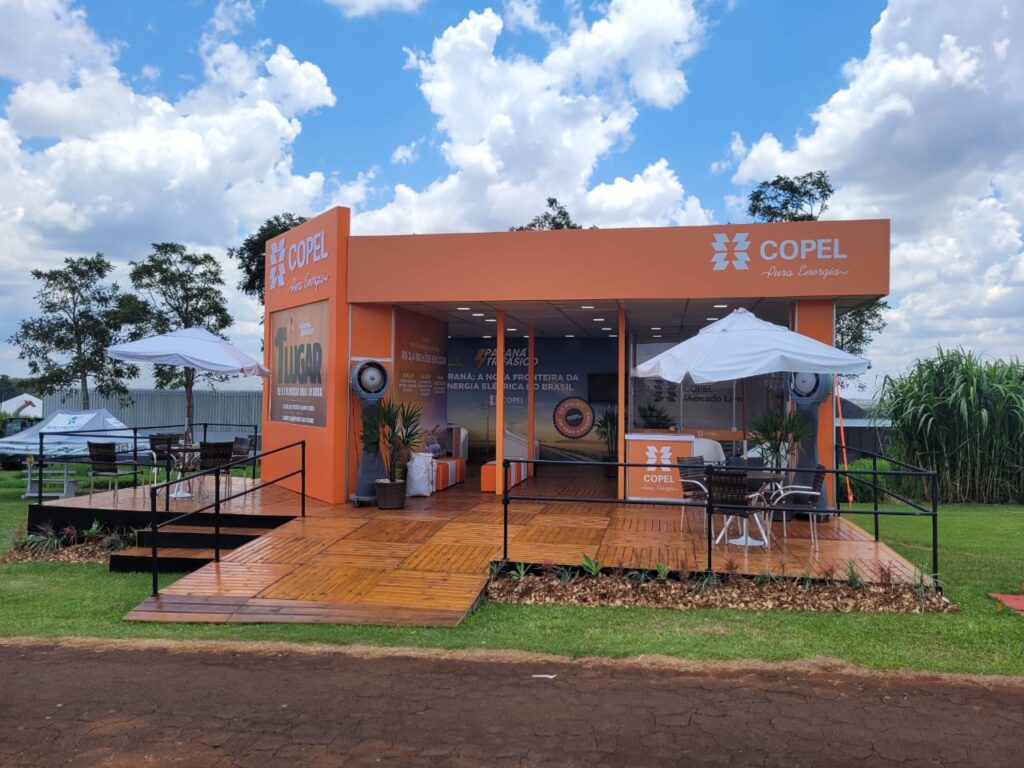 Fachada do estande da Copel no Show Rural em Cascavel. Estande em madeira e detalhes em laranja.